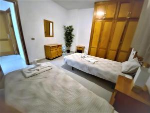 Cette chambre comprend 2 lits et une commode. dans l'établissement Sea La Vie. Playa la Arena, à Puerto de Santiago