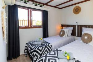 2 camas en una habitación con ventana en Cabana incl boat, jacuzzi,subboarts on a quiet park with private parking, en Loosdrecht