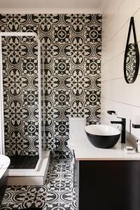 a bathroom with a black and white patterned wall at Ontevreden Farm in Montagu