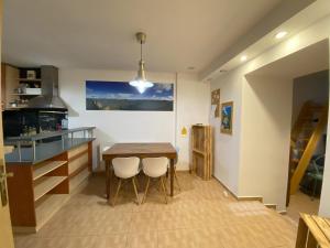 a kitchen with a wooden table and two white chairs at Cozy Downtown Garden Apartment: Spacious, Historical & Culinary Delight! in Prague