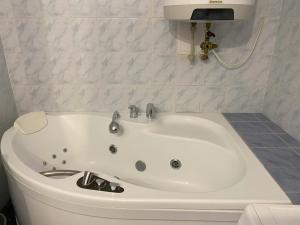 a white bath tub in a bathroom with a sink at Cozy Downtown Garden Apartment: Spacious, Historical & Culinary Delight! in Prague