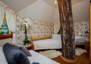 um quarto com duas camas e uma árvore em Dom na strome v Panoráma Parku em Nezbudská Lúčka