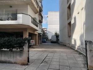 a building with a balcony and a parking lot at DZ Apartment AXD in Alexandroupoli