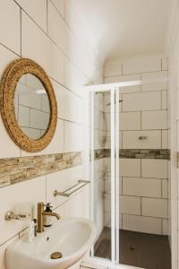 a white bathroom with a sink and a shower at Ontevreden Farm in Montagu