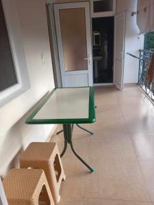 Beka’s House في كوبوليتي: طاولة زجاجية و كرسيين في الغرفة