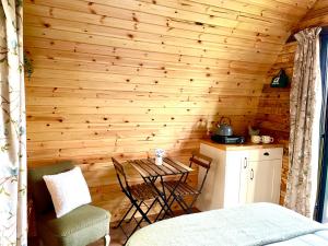 a room with a wooden wall with a table and chairs at Willow Pod in Great Ayton