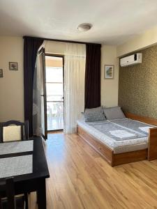 a bedroom with a bed and a table and a window at Sozopol Harmani Beach Apartment 10 in Sozopol
