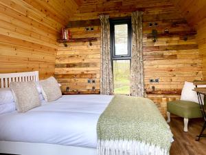 a bedroom with a bed in a log cabin at Willow Pod in Great Ayton