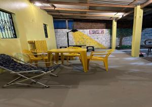 een gele tafel en stoelen in een kamer bij Casa Amarela in Presidente Figueiredo