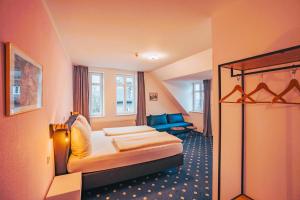 une chambre d'hôtel avec un lit et un canapé dans l'établissement Hotel Starke, à Brilon