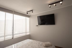 um quarto com uma cama e uma televisão de ecrã plano em PRO HOME NOVO em Antofagasta