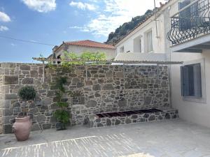 a stone wall with a vase next to a building at Loukia in Kondiás