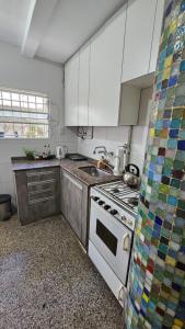 uma cozinha com armários brancos e um forno com placa de fogão em Casa San Carlos em Rosário