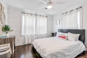 a white bedroom with a bed with a hello pillow on it at Bungalow Bliss - Large Backyard & Fire Pit in McGregor