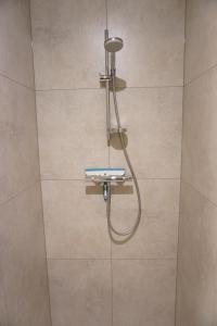 una ducha con cabezal de ducha en un baño en Faro Greenpark APP 01, Cadzand-Bad, en Cadzand 23 fotos más