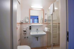 La salle de bains est pourvue d'un lavabo, de toilettes et d'un miroir. dans l'établissement Hotel Starke, à Brilon