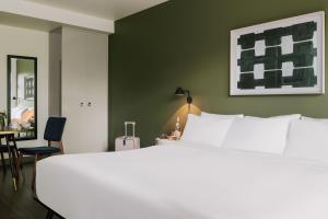 um quarto com uma cama branca e uma parede verde em Sonder at Revival em Vancouver