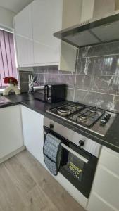 cocina con fogones y encimera en Enquire now - 3 bed house - Up to 35% off - Contractors and Families, en Coventry