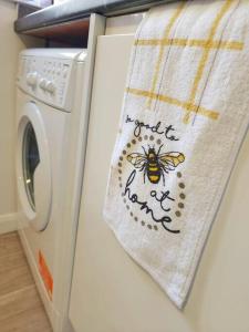a towel with a bee on it next to a washing machine at Enquire now - 3 bed house - Up to 35% off - Contractors and Families in Coventry