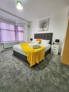 Un dormitorio con una cama grande con una manta amarilla. en Enquire now - 3 bed house - Up to 35% off - Contractors and Families, en Coventry