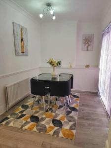 a dining room with a table and chairs on a rug at Enquire now - 3 bed house - Up to 35% off - Contractors and Families in Coventry