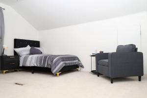 a bedroom with a bed and a couch and a chair at Charming, Central, Cozy Home - Ideal in Dearborn Heights