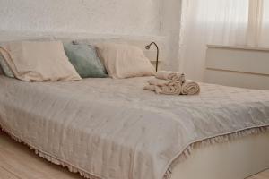 a white bed with a pile of towels on it at Urban Harmony Nest in Arona