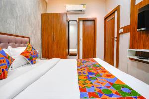 a bedroom with a bed with a colorful comforter at FabExpress Affari in Mumbai