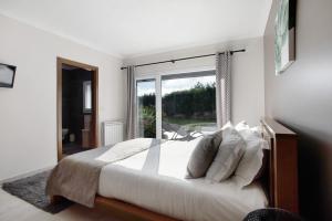 a bedroom with a large bed and a large window at Villa Mila Piscina e Jacuzzi in Salir de Matos +34 photos