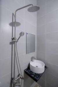 a white bathroom with a sink and a mirror at Quốc Thắng Hotel in Vung Tau