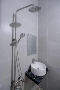 Un baño blanco con lavabo y espejo. en Quốc Thắng Hotel, en Vung Tau