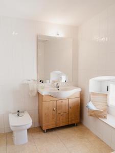 uma casa de banho com um lavatório, um WC e um espelho. em La Maysou em Masroig