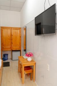 um quarto com uma mesa e uma televisão na parede em Quốc Thắng Hotel em Vung Tau