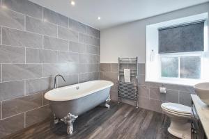 een badkamer met een bad, een toilet en een wastafel bij Host & Stay - The Orchard in Cramlington