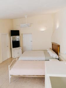 Duas camas num quarto branco com uma cozinha em La Maysou em Masroig