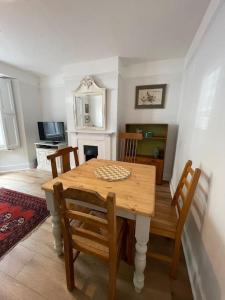 uma sala de jantar com uma mesa de madeira e cadeiras em Homely garden apartment, newly refurbished - sleeps four em Brighton & Hove