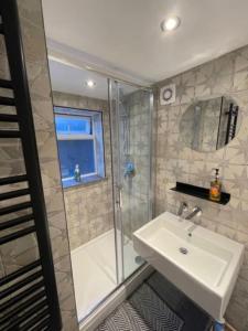 y baño con lavabo y ducha. en Homely garden apartment, newly refurbished - sleeps four en Brighton & Hove