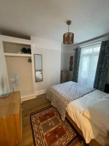 1 dormitorio con cama, mesa y ventana en Homely garden apartment, newly refurbished - sleeps four, en Brighton & Hove