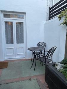 a patio with a table and chairs next to a door at Homely garden apartment, newly refurbished - sleeps four in Brighton & Hove