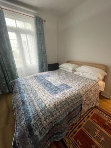 a bedroom with a bed with a quilt on it at Homely garden apartment, newly refurbished - sleeps four in Brighton & Hove