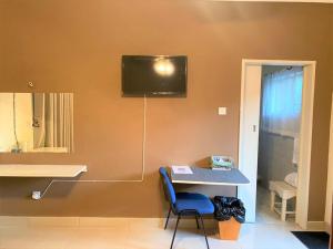 Habitación con mesa con silla y TV en la pared. en Luxurious suite with outdoor pool - 2171 en Bulawayo