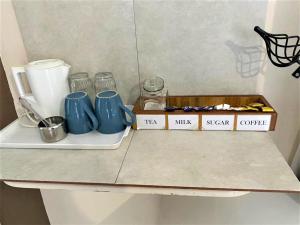 a shelf with cups and a box on it at Luxurious suite with outdoor pool - 2171 in Bulawayo