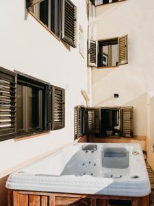 a bath tub in a room with windows at La Maysou in Masroig