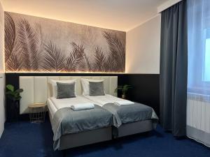 a bedroom with a bed with a painting on the wall at Cube House Aparthotel in Krakow