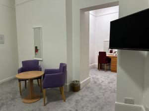 um quarto com uma mesa e duas cadeiras e uma televisão em Best Western Exmouth Beach Hotel em Exmouth