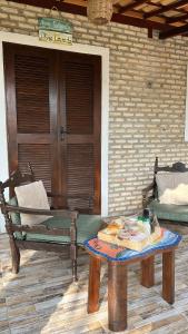 a patio with a bench and a table and a door at Fiquei In Pipa - Chalé 21 in Pipa