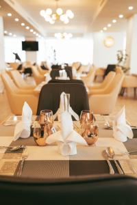 una mesa con copas de vino y flores blancas. en AYA Addis Hotel en Addis Abeba