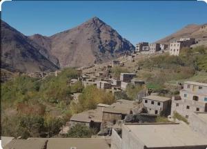 a group of buildings on a hill with a mountain at riad jnane imnane in Tamguist