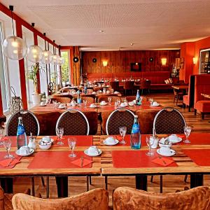a restaurant with wooden tables and chairs and blue bottles at Hotel Starke in Brilon