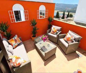 un patio con 2 sofás y una mesa en La Casa Siglo Ocho, en Iznájar